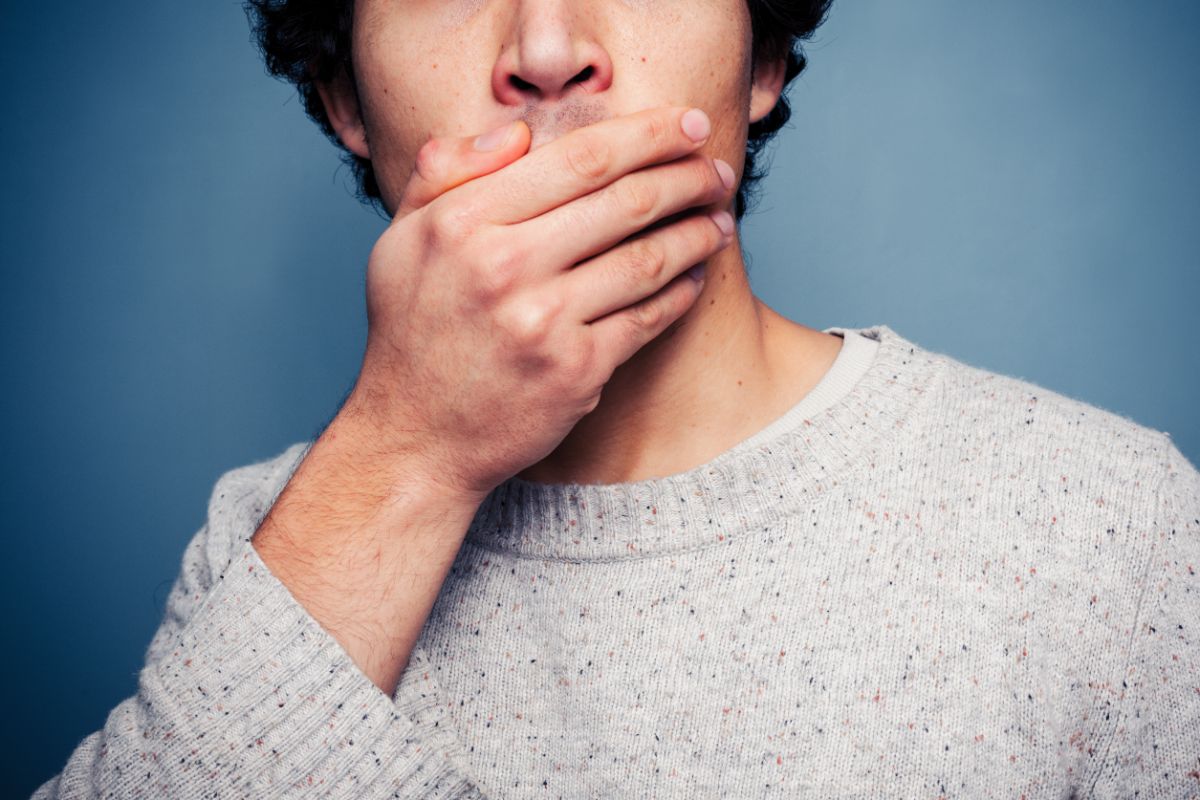 Man covering his teeth