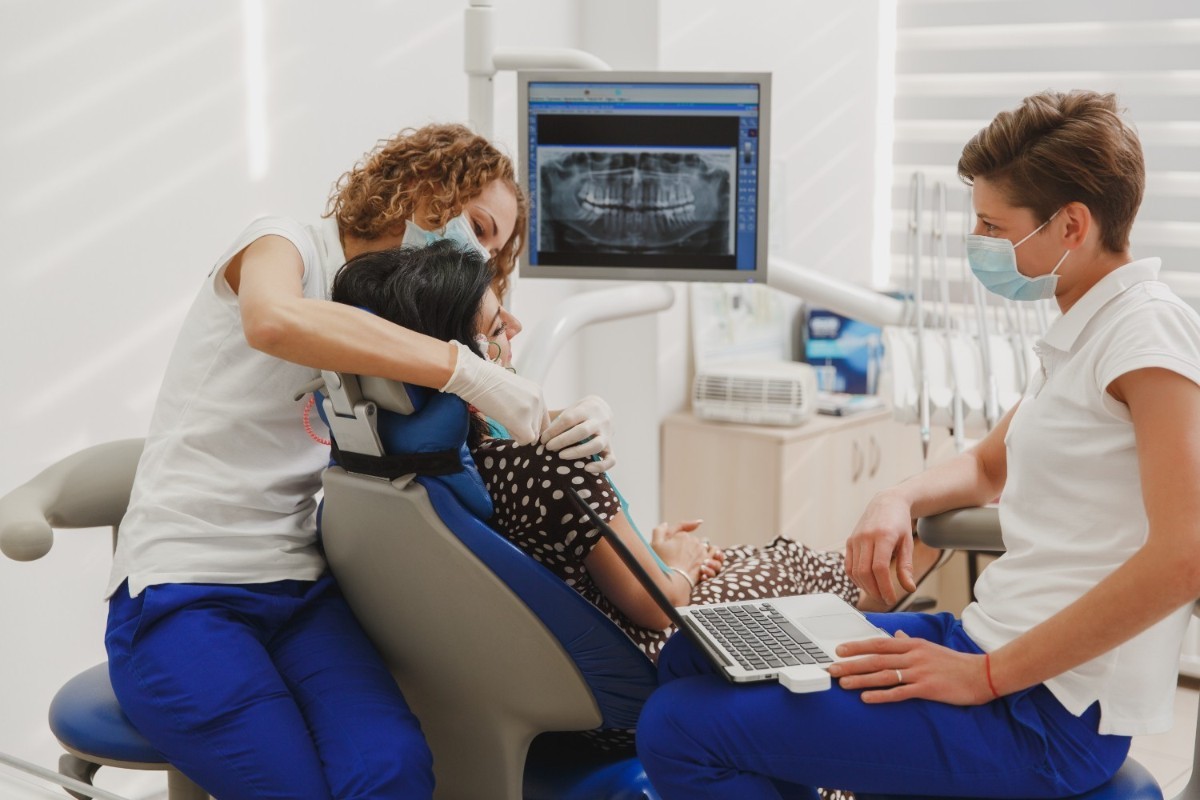Woman at dentist's office with dental assistants