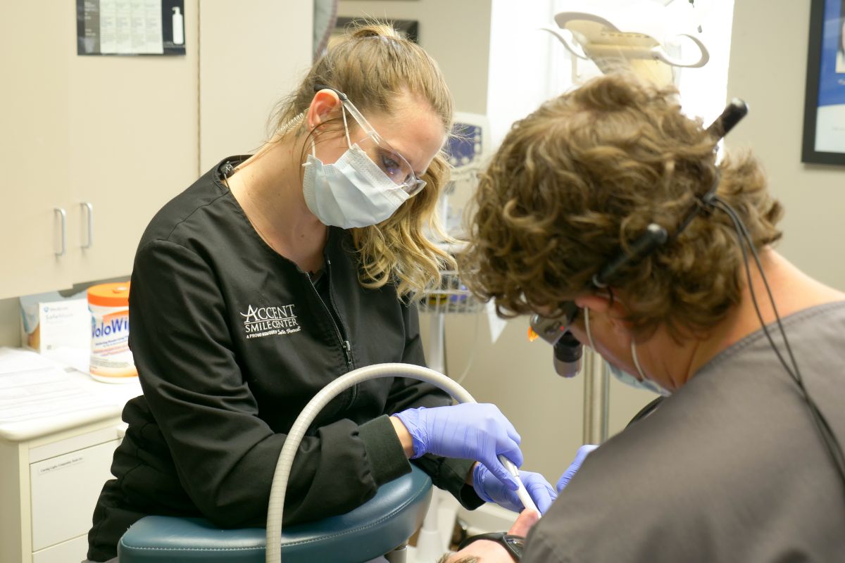 Accent Smile Center assistant helping Dr. Ford work on a patient's teeth